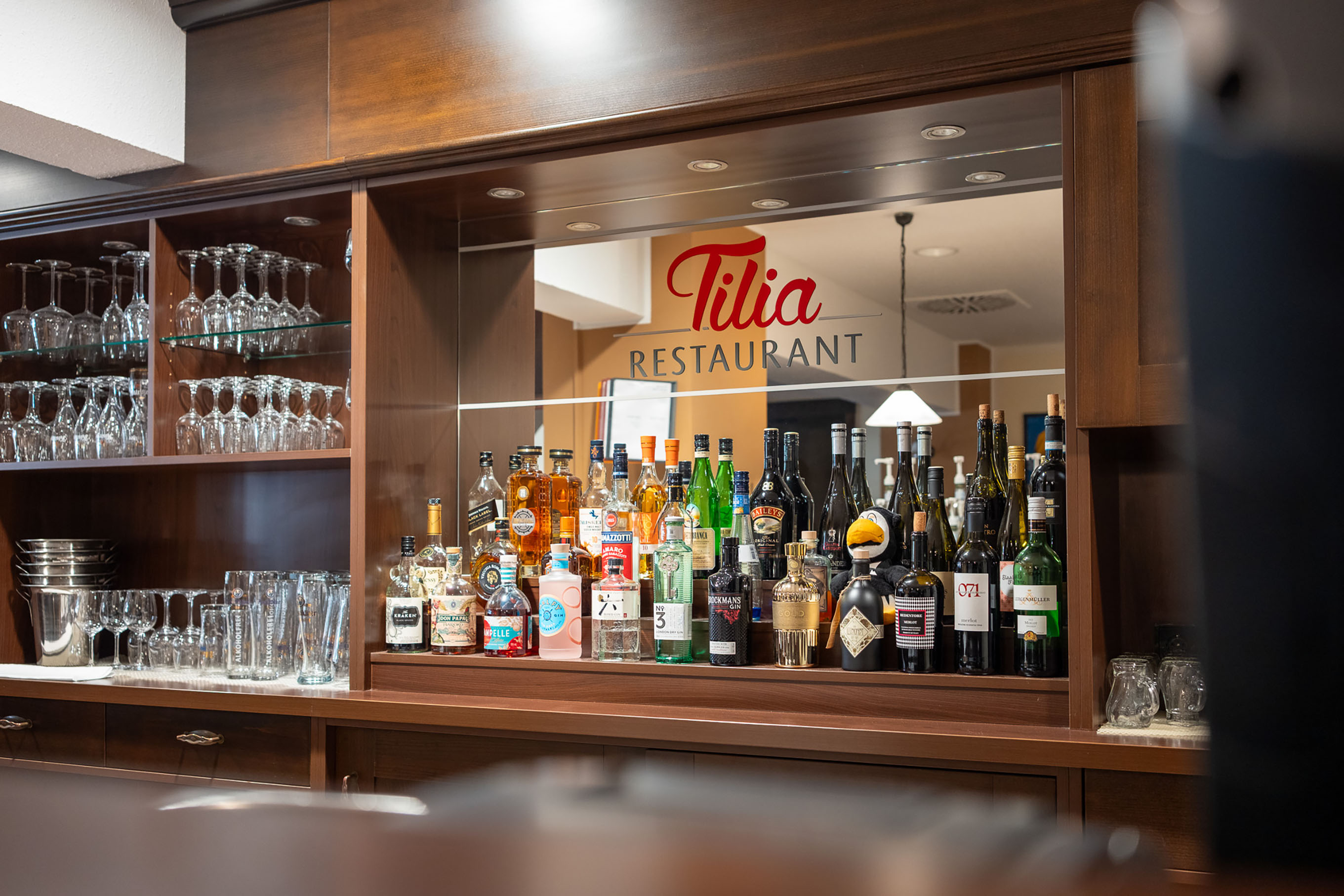 Barbereich mit beleuchtetem Tilia-Logo im Restaurant